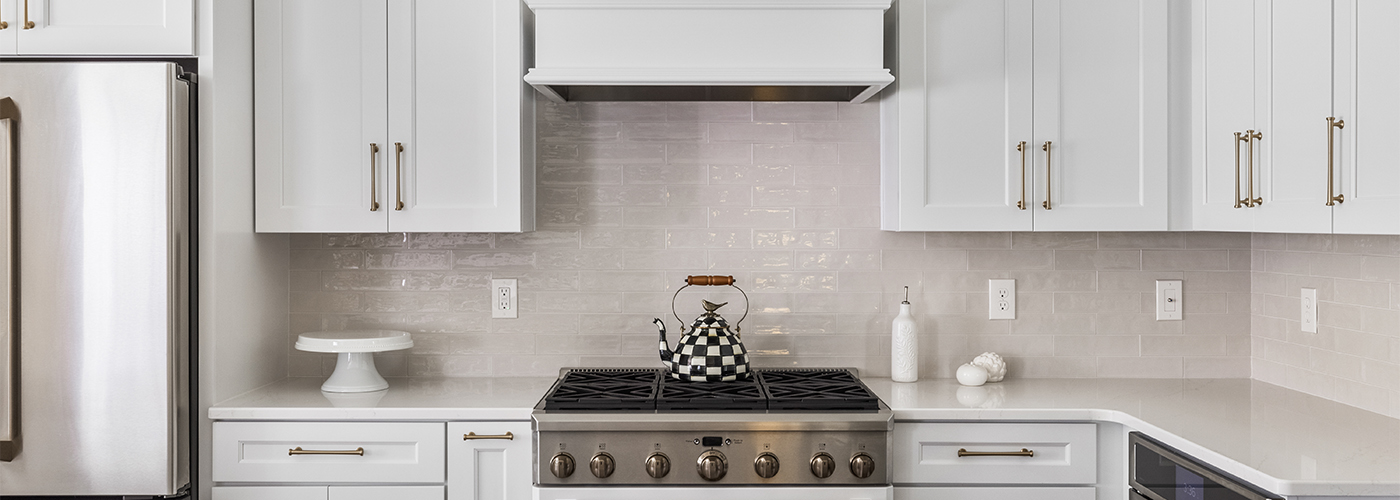 tea top on stainless steel range in all white modern kitchen remodel