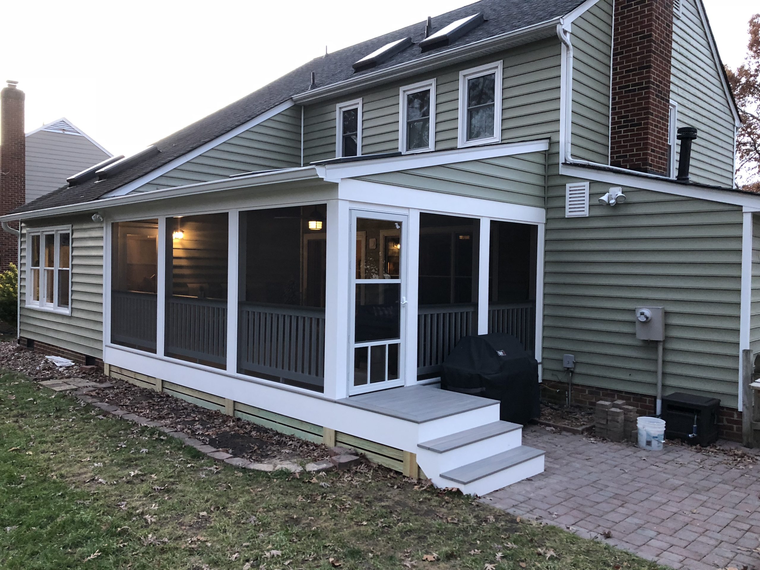 green hardie plank siding around newly built screen porch